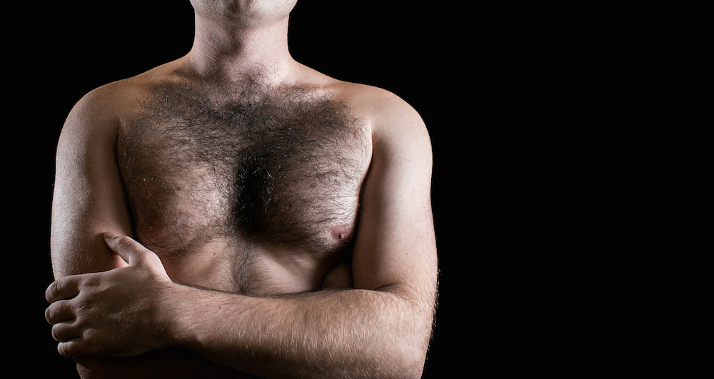 Man with hairy chest isolated on black background.